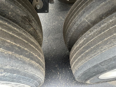 Trailer wheel area showing dual heavy tires with visible tread and dirt; part of a Timpte hopper trailer.