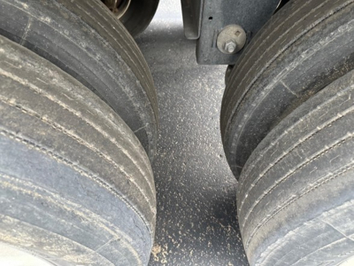 Timpte Super Hopper trailer dual rear wheels showing treaded tires and dusty ground.