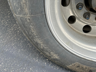 Timpte Super Hopper trailer wheel and tire close-up with metal rim and lug nuts visible.
