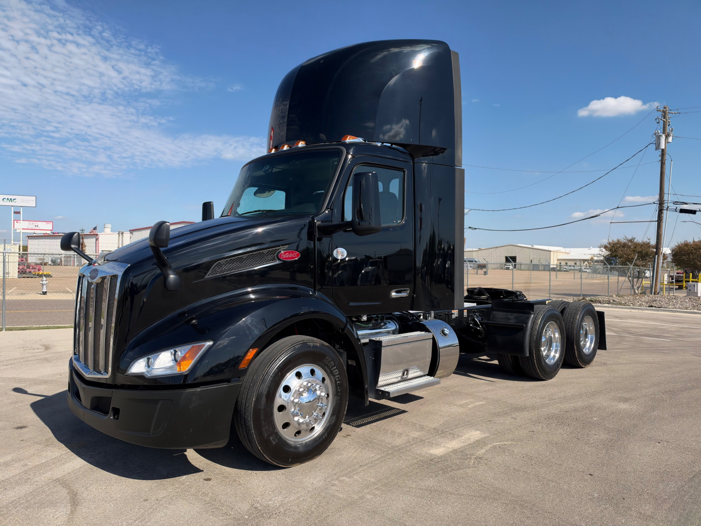 Peterbilt 579 conventional daycab tractor in black, side view showing cab roof exhaust stack, chrome fuel tanks, and dual rear axles; no visible badges or text on the image.