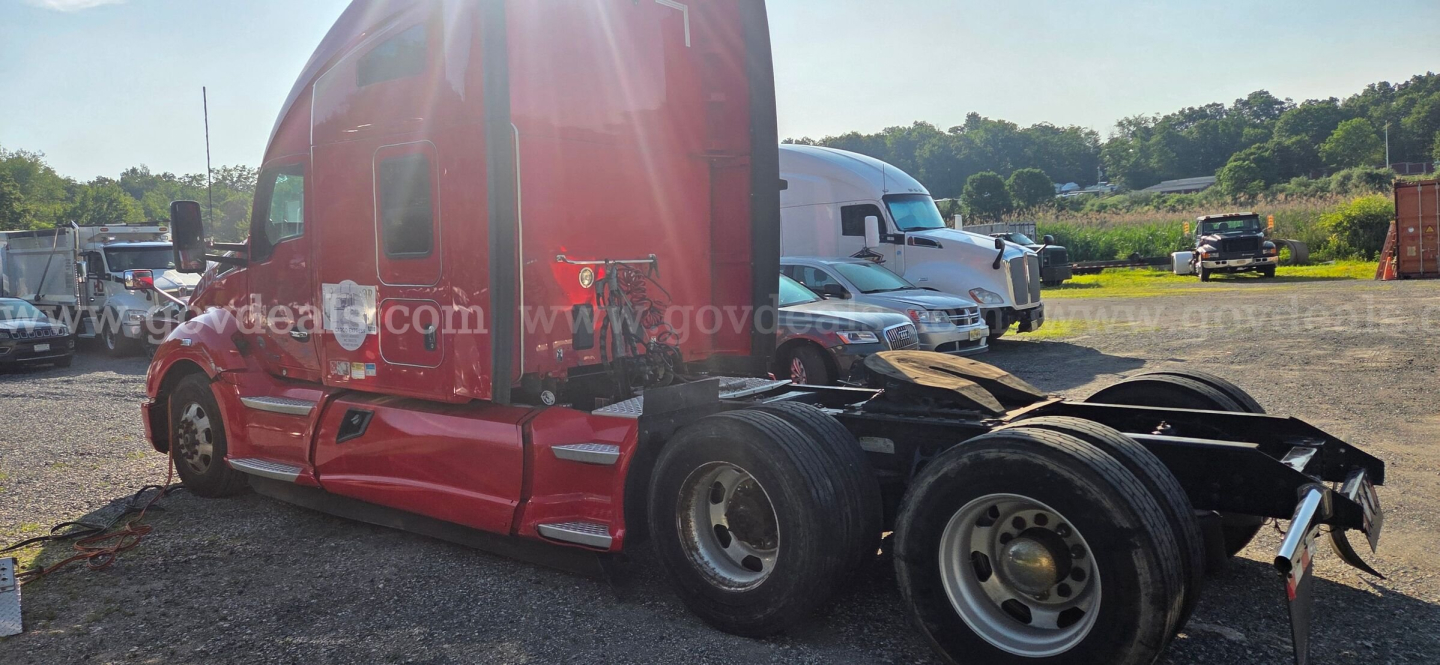 Kenworth T680 side view showing red cab and detached rear axle with dual wheels; no visible text on the cab exterior.