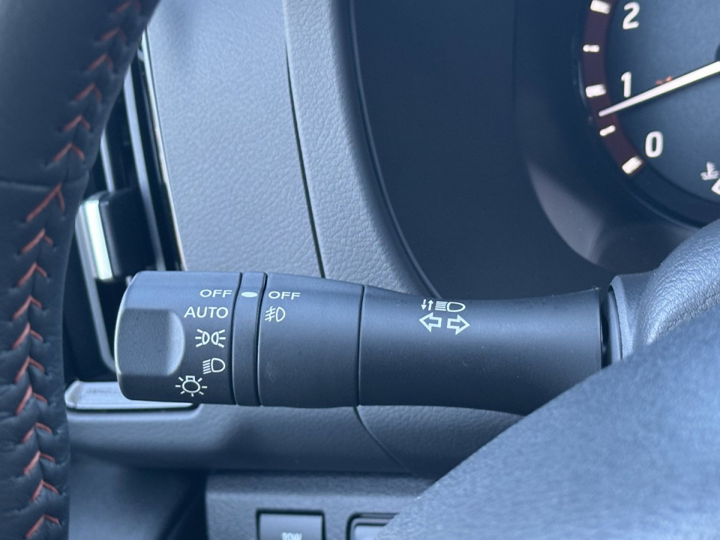 Nissan Frontier steering column stalks and dashboard controls with light switches visible.
