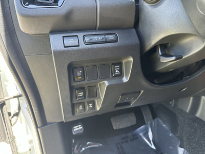Dashboard controls on the left side of a Nissan Frontier interior showing multiple switches and a steering column in view.