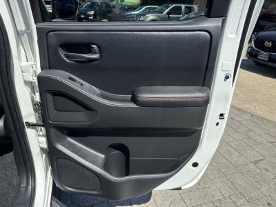 Frontier truck door interior panel with armrest and control switches visible.