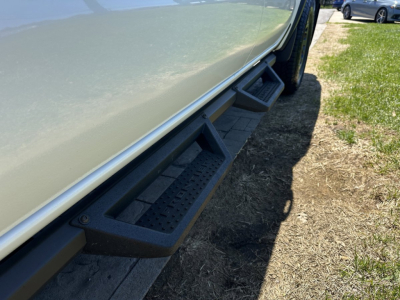 Nissan Frontier side view showing running boards under doors and lower body panel.