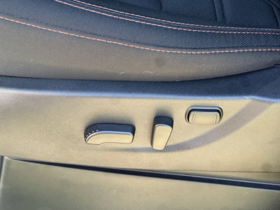 Vehicle seat adjustment controls on a Nissan Frontier interior, showing power recline and lumbar adjustment buttons.