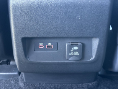 Front-seat center console with two USB-C ports and a 12V power outlet in a Nissan Frontier cabin.
