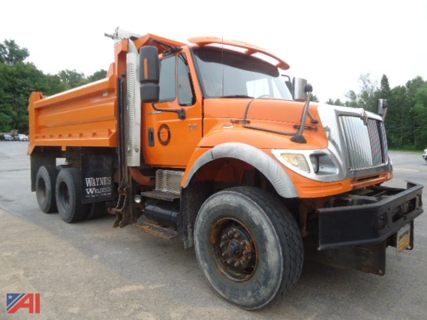 Orange 2007 International WorkStar 7600 dump truck with plow and wing, front view showing large tires and cargo bed.