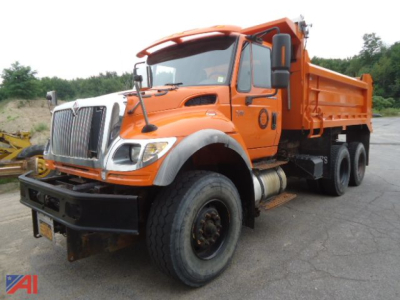 Dump truck chassis and cab in service showing orange dump body and plow/wings attachment on a heavy-duty International WorkStar 7600.