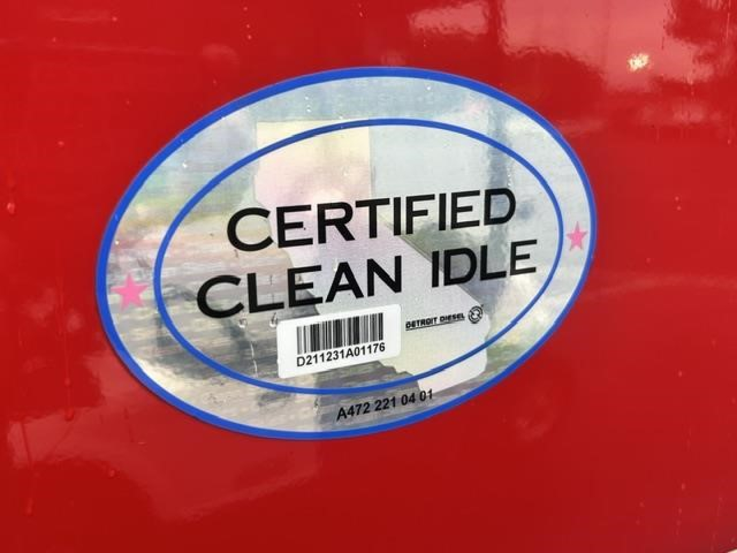 Label sticker reading CERTIFIED CLEAN IDLE on red truck door with barcode and serial numbers.