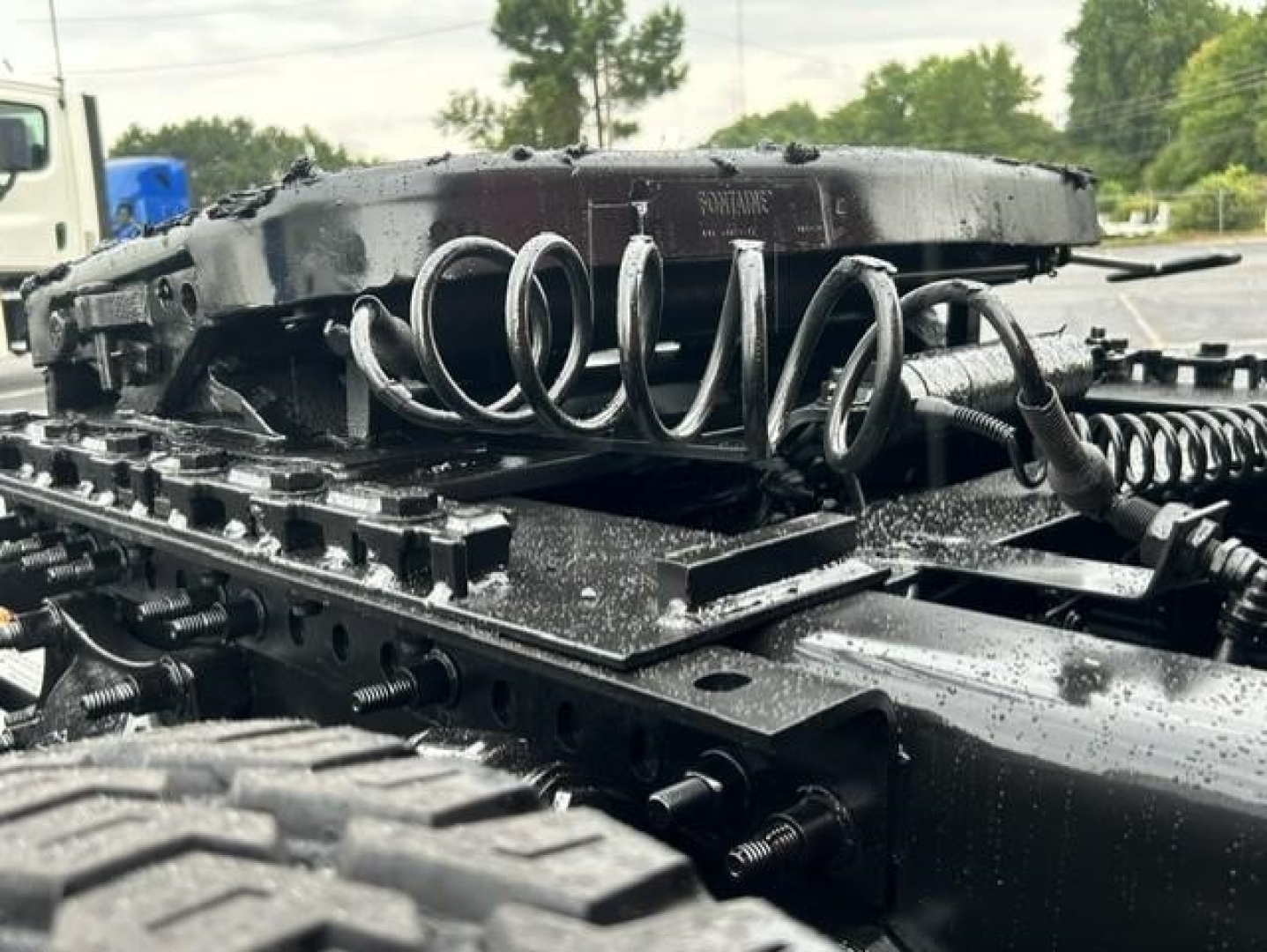 Freightliner Cascadia truck chassis showing coil spring suspension and mounting hardware.