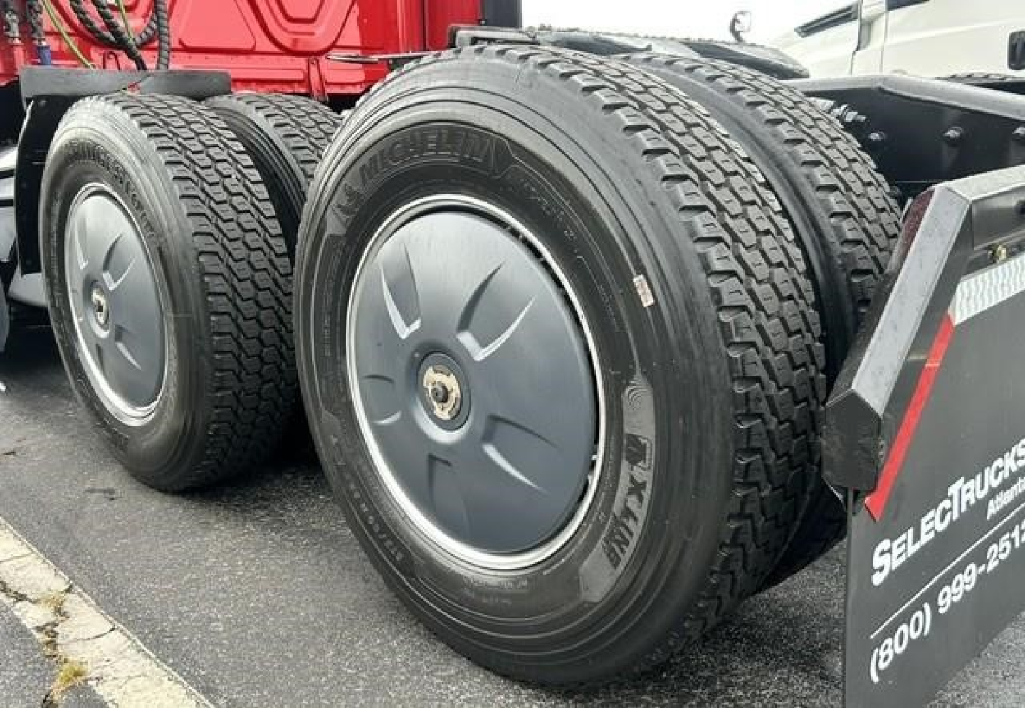 Conventional sleeper Freightliner Cascadia truck rear dual tires showing Michelin rubber and wheel covers.