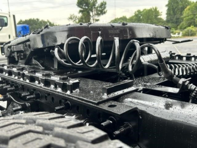 Freightliner Cascadia truck chassis showing coil spring suspension and mounting hardware.