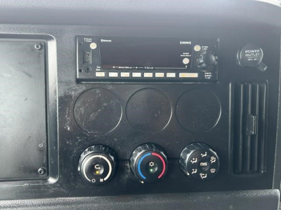 Dashboard panel of a Freightliner Cascadia showing radio/CD unit and climate control dials.