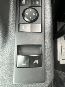 Truck interior showing window/lock controls and two switch buttons on armrest