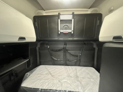 Freightliner Cascadia sleeper cab interior with bed area and storage nets visible.