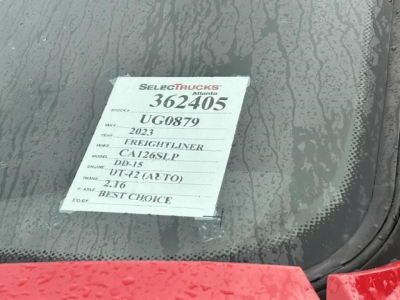 Truck window with a white SelectTrucks tag showing stock 362405, UG0879, 2023 Freightliner Cascadia DX-15 engine, CA126SLP, DD-15, 2.16 axle ratio, Best Choice.