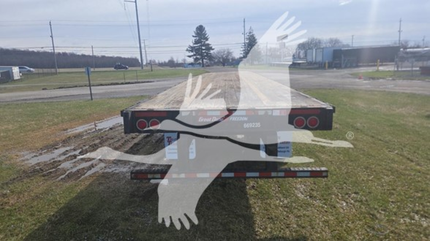 Flatbed trailer back view showing dual tail lights, rear bumper, and mounting hardware on a 2016 Great Dane steel flatbed