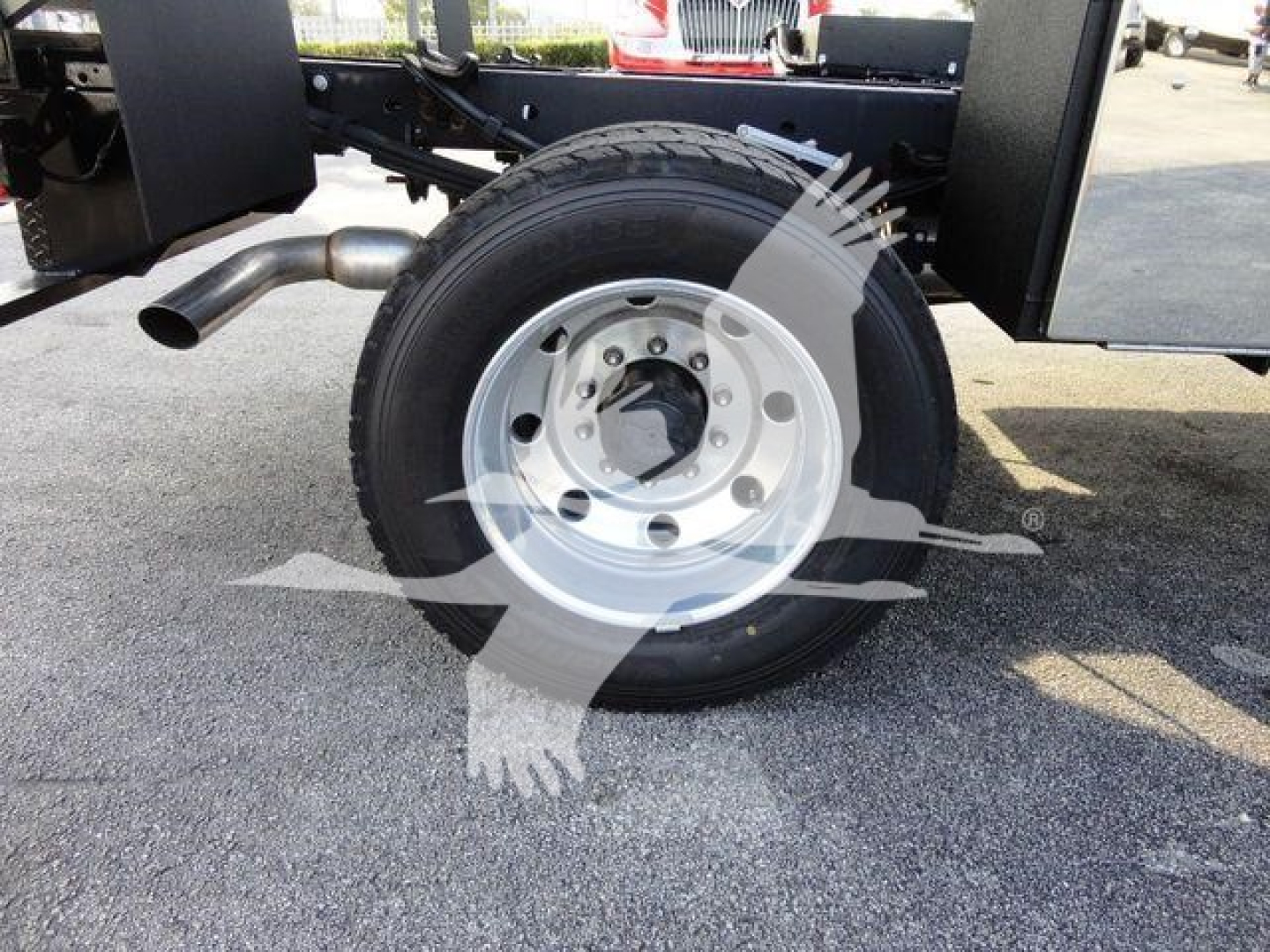 Wheel and tire assembly of a 2022 Ford F600 chassis showing single rear axle with 6-lug wheel and exhaust pipe nearby.