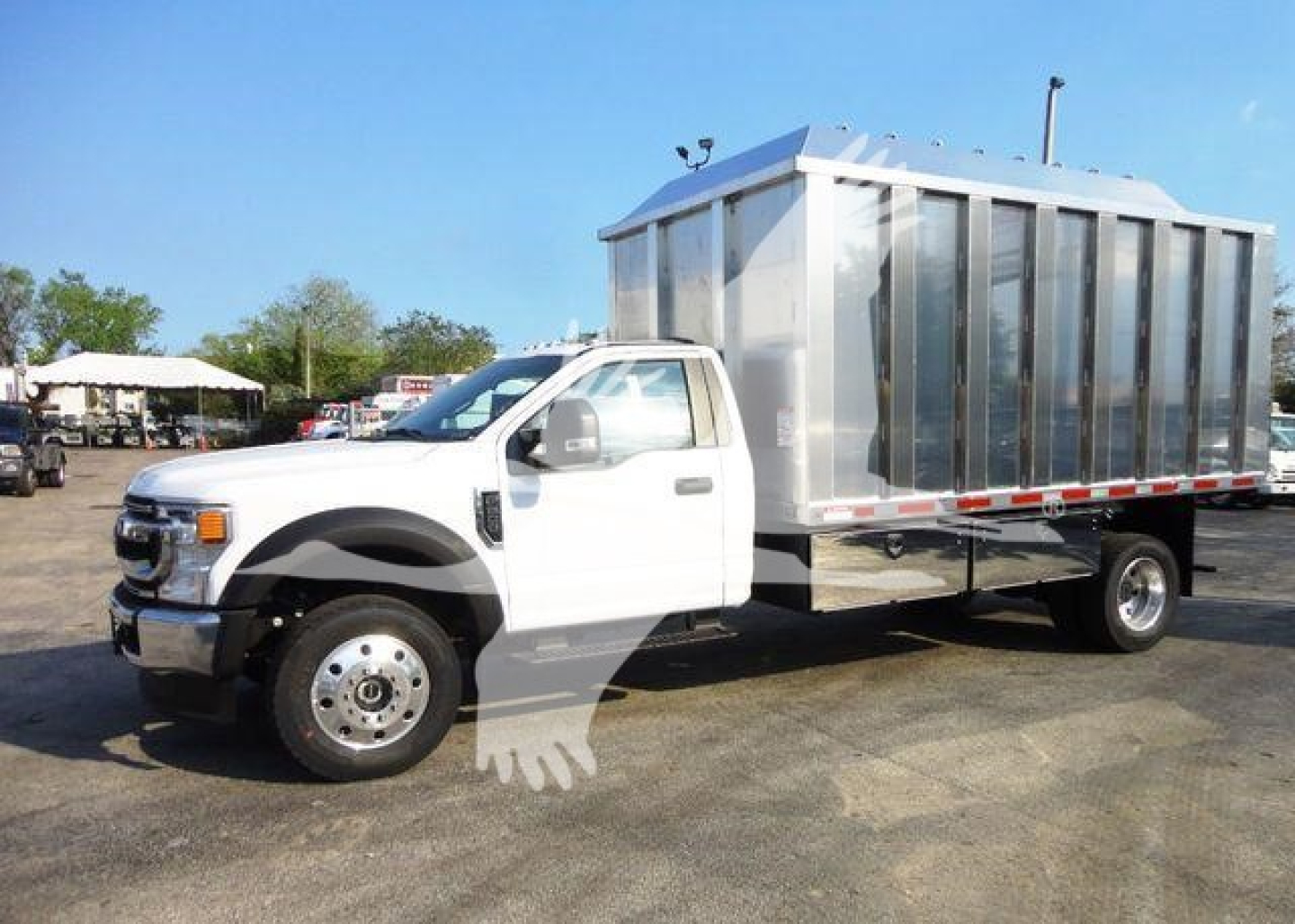Ford F-Series cab chassis with a large metal box body, white truck on a lot. No visible decals or text legible on the vehicle in this view.