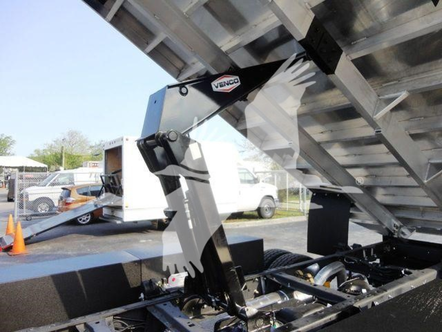 Ford F-600 truck chassis with hydraulic lifting mechanism and chipper attachment visible in raised position.