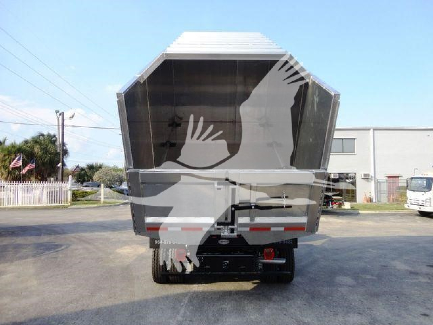 rear view of a Ford F-600 dump truck/chipper body showing open cargo bed and rear bumper with taillights.