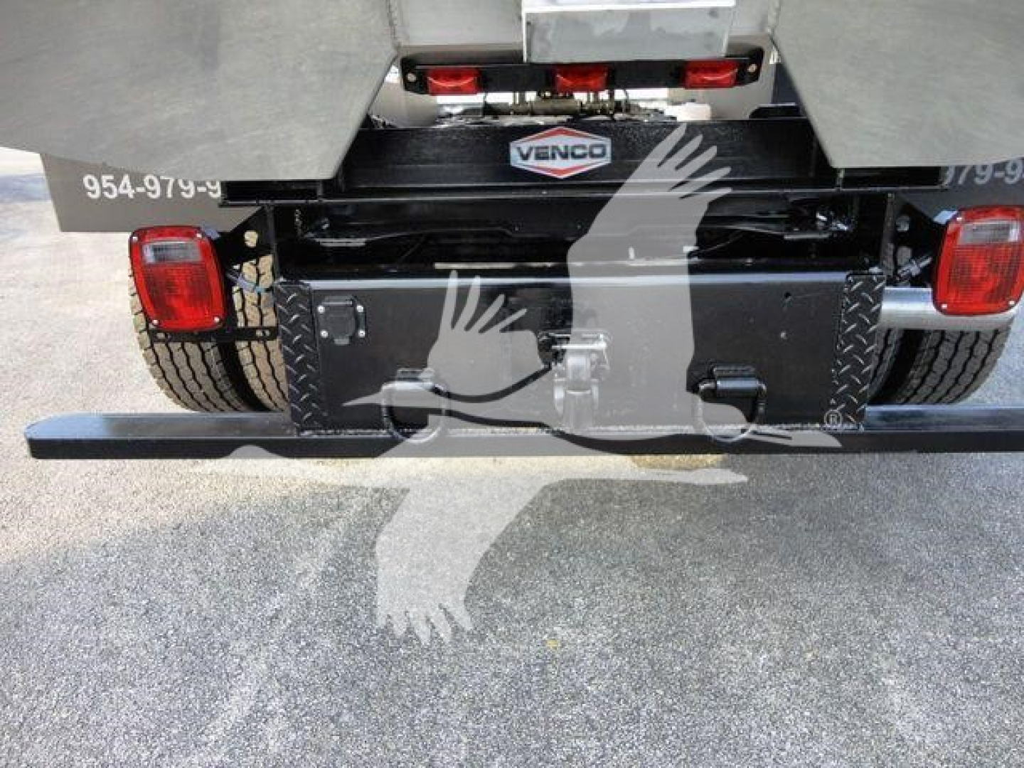 Truck rear showing bumper step and Venco chipper access box with tail lights and hazard reflectors.