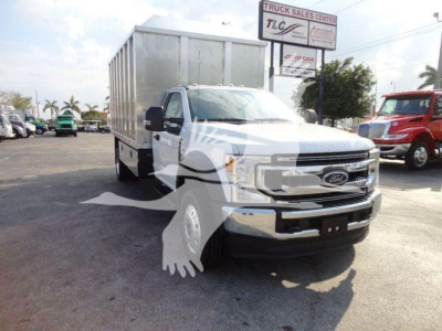 Ford F-600 chassis cab truck with a large enclosed cargo box, white exterior, front grille, and side mirror view in a dealership lot.