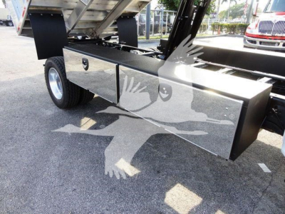 Chipper truck bed side toolbox with polished aluminum drawers on Ford F-600 chassis, underbody hydraulic components visible.