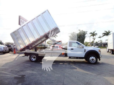 2022 Ford F600 front view showing dump bed tilted up on service lot with chipper truck tag.