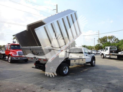 Truck bed tilted dump body on a Ford F-600 chassis showing dump bed and rear wheels.