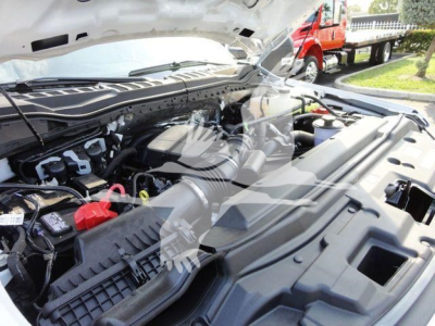 Trucks engine bay with hood open showing Ford F-600 chassis and engine components.