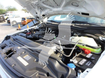 Ford F600 engine bay with hood open; visible labels on fluid reservoirs and components, including blue reservoir cap, red cap, and various hoses and wiring. Some text on stickers and caps may be legible.