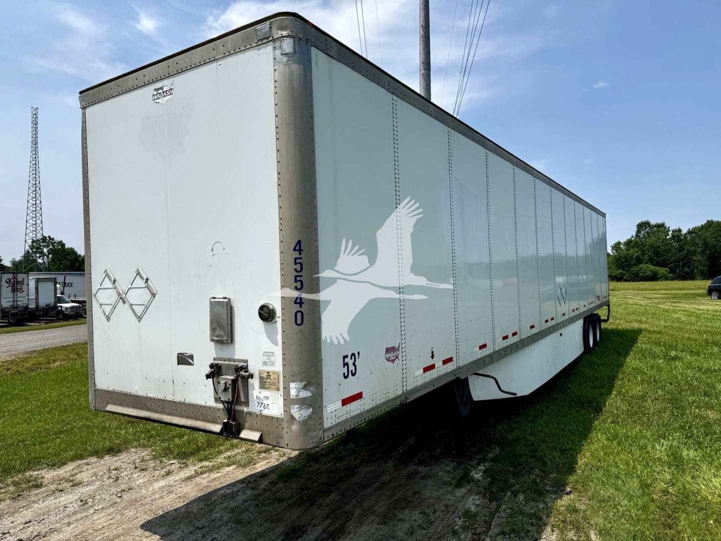 Box trailer with rear doors, side markings, and numbers: 45540 vertical on rear corner; 53" height marking near side; small diamond placard; rear frame hitch and lock mechanism; taillight and reflectors along lower edge.