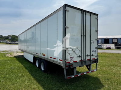 Wabash dry van trailer showing side panels, rear doors, and triple-axle setup. Visible text includes 'DRY VAN' branding and serial markings on rear.