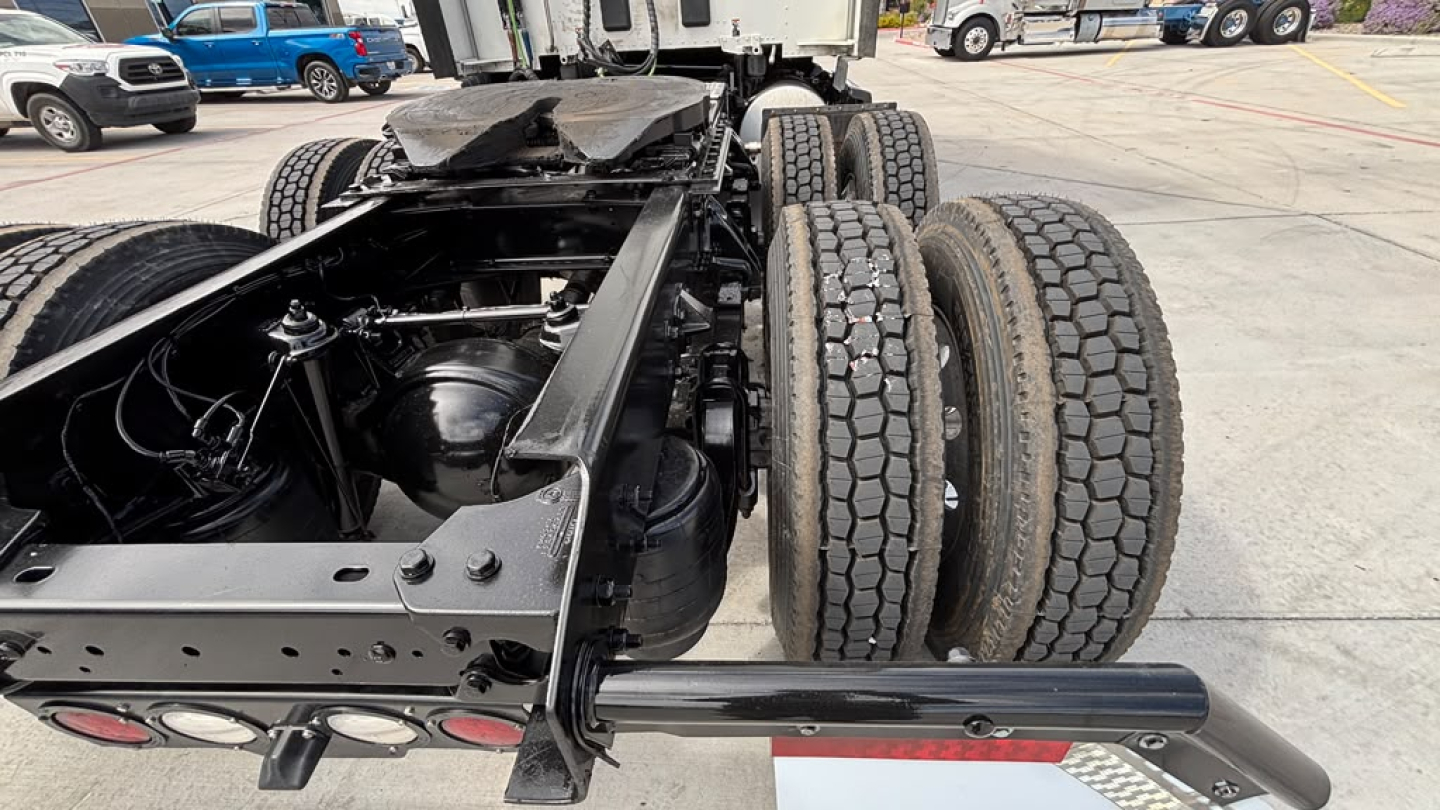 Kenworth T680 chassis showing rear dual-axle setup and suspension with visible tires and frame; no engine bay visible.