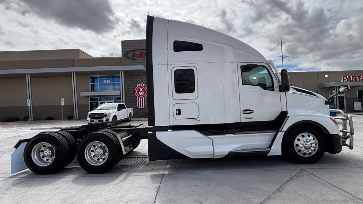 Kenworth T680 conventional sleeper tractor showing side view with white cab and dual rear axles.