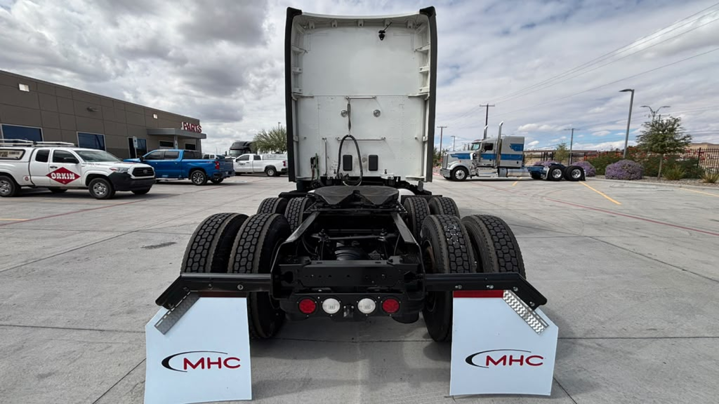 Truck chassis rear view showing fifth wheel and dual rear axles with mud flaps labeled MHC.