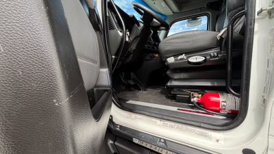 Kenworth T680 cab interior showing driver seat area and floor with red fire extinguisher and entry step.