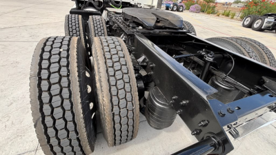 Kenworth T680 chassis and dual rear axles with dual tires in view; black framing and suspension components visible.