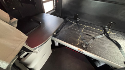 Kenworth cab interior showing sleeper area with bed platform and storage drawer under seat.