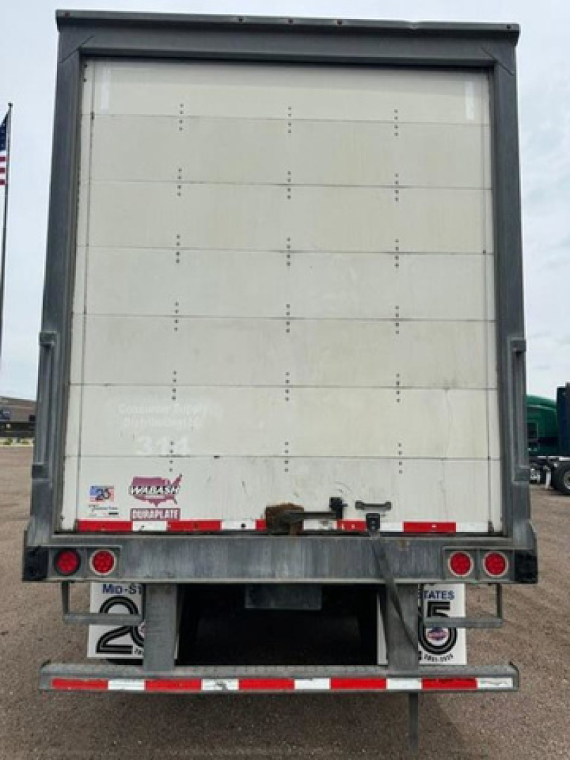 Rear view of a 2016 Wabash van trailer showing back doors and bumper with clearance lights and license plate area.