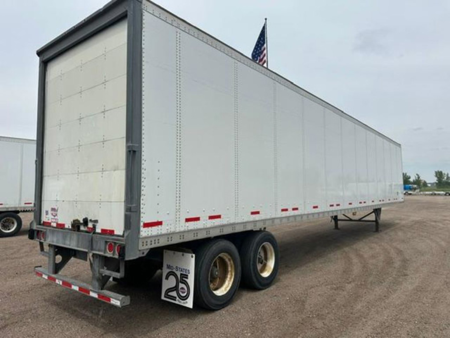 2016 Wabash van trailer with tandem axles, white exterior, rear doors, and reflective tape along the sides.