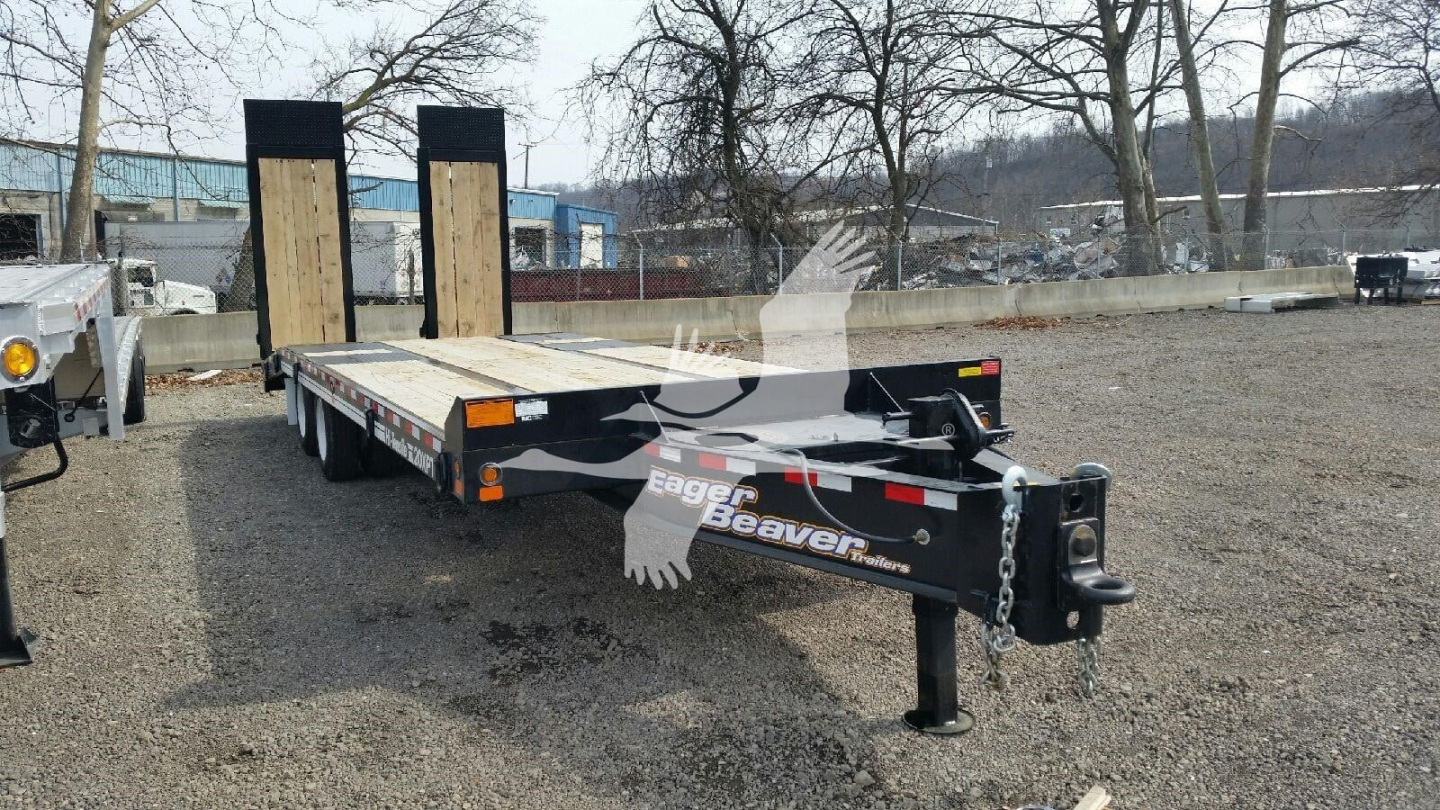 Trailer showing flatbed gooseneck with dual ramps and front hitch, Eagle Beaver logo on frame, black and gray color, tag trailer.