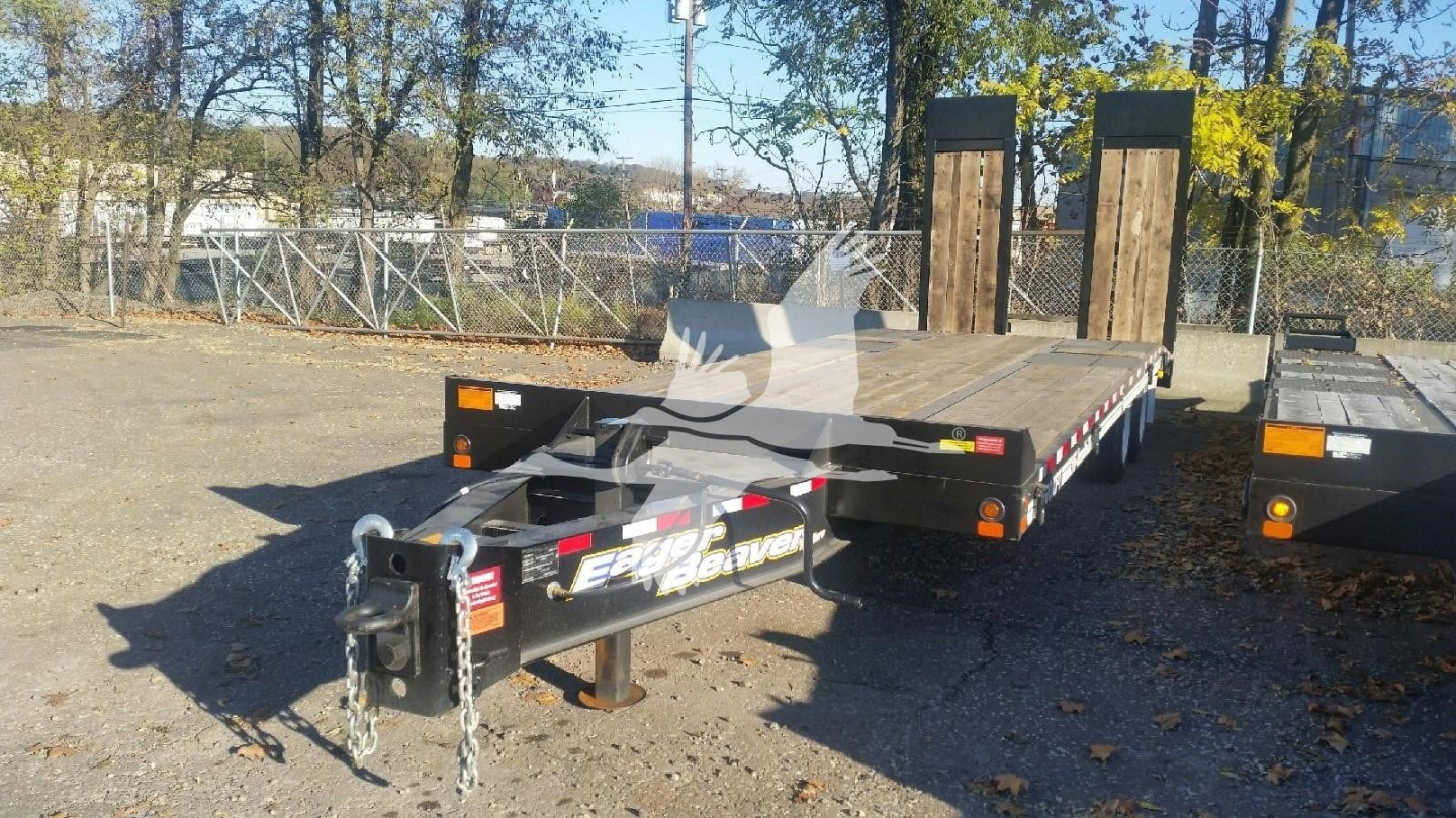 Flatbed trailer showing gooseneck hitch and dual ramps with safety chains; Eager Beaver branding visible on side.