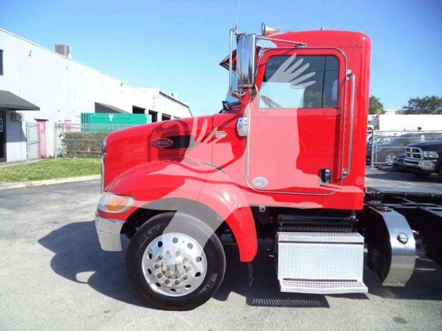 Peterbilt 337 rollback truck side profile showing red cab and chrome fuel step, front wheel and bumper visible.