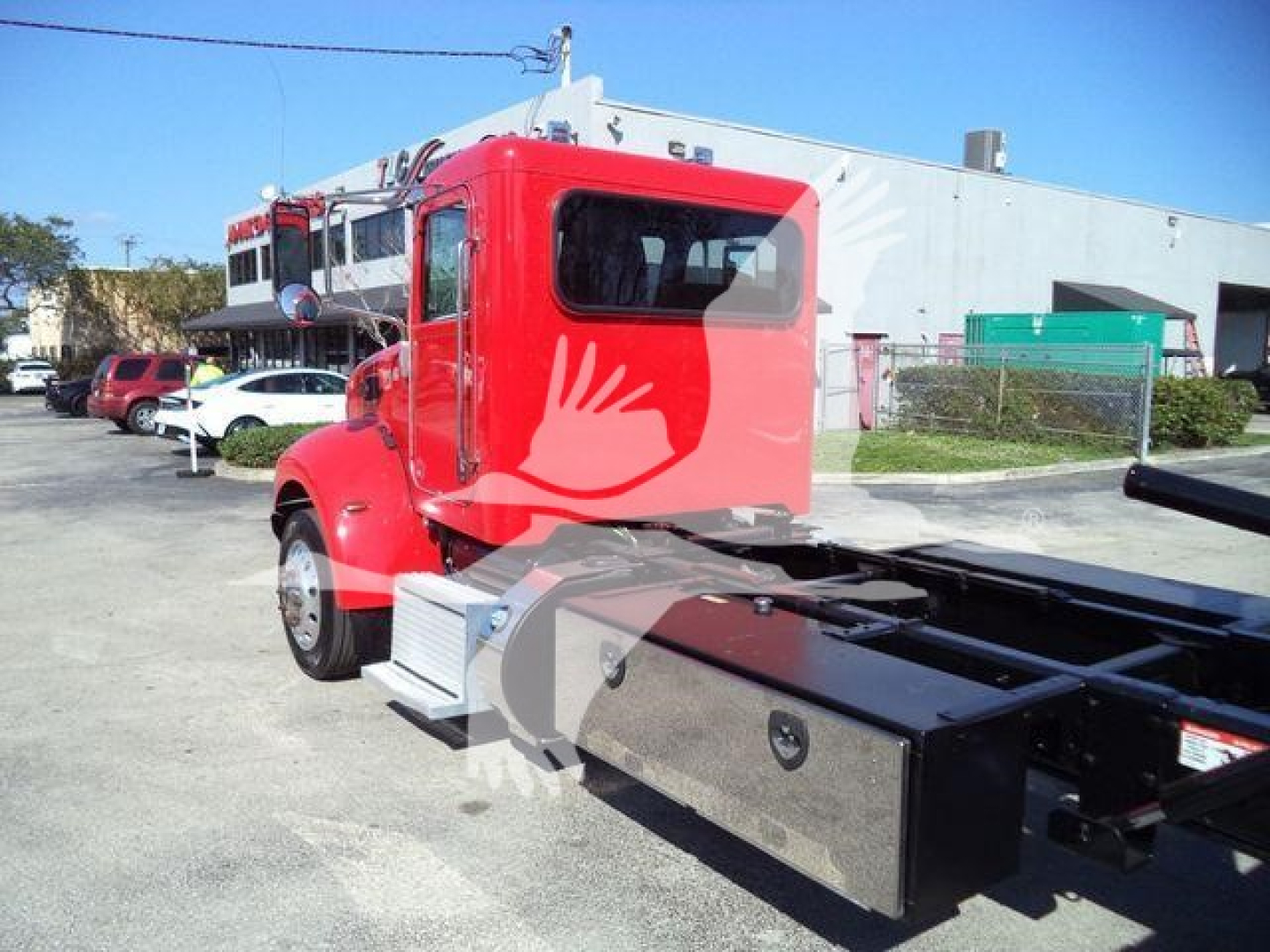 Peterbilt 337 rollback truck in red cab with flatbed chassis showing rear side and window