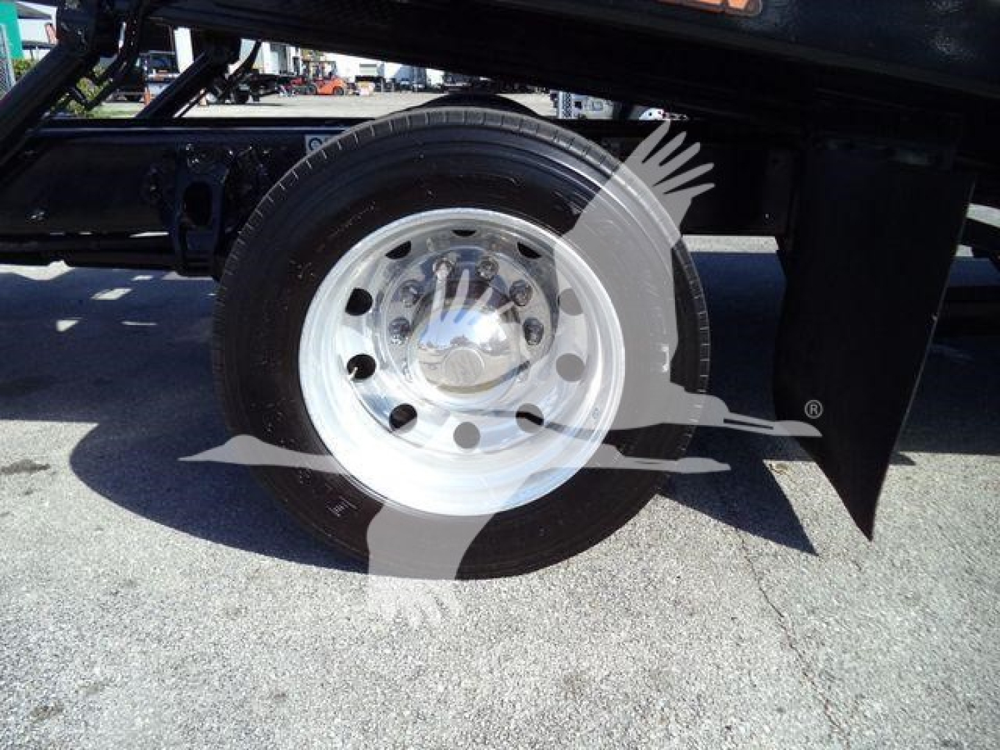Peterbilt 337 truck wheel and fender area showing chrome hubcap and single rear wheel under rollback bed.