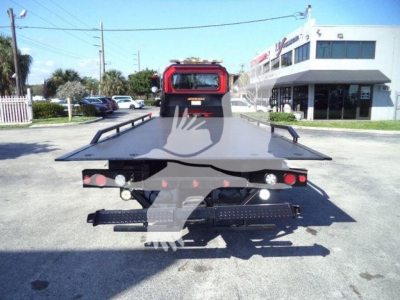 Rollback tow truck bed on a 2020 Peterbilt 337, view of rear with ramps and lights, in a lot.