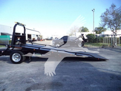Truck rollback trailer with low-angle view showing front and ramped bed and Peterbilt logo not visible.